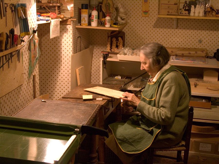 Sofia Cavalletti sägt in ihrer kleinen geordneten Werkstatt mit einer Laubsäge eine Figur aus.