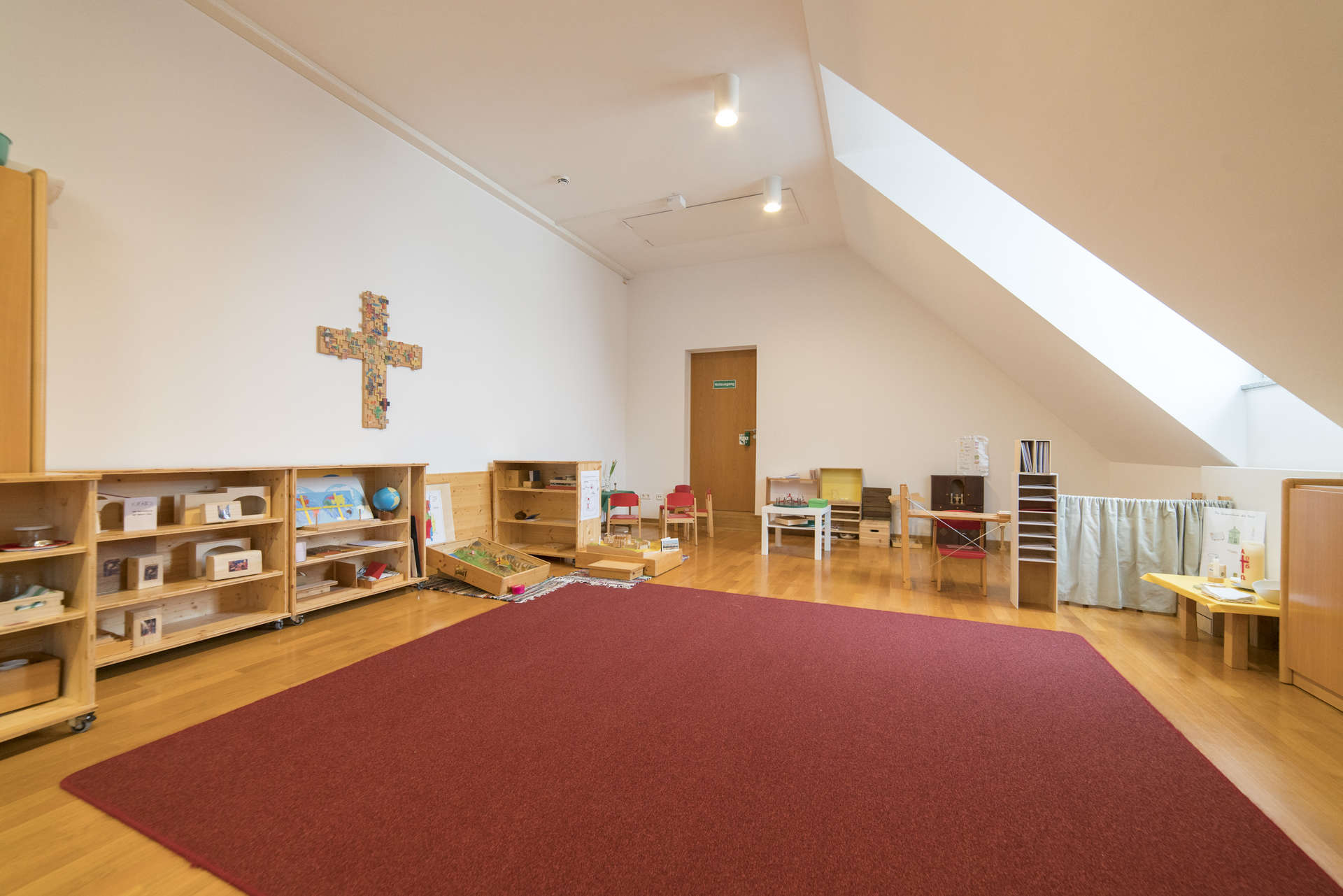 Ein Raum unter dem Dach mit hellem Tageslicht und offenen Regalen für die Materialien der Stufe I ist das Atrium Stufe I