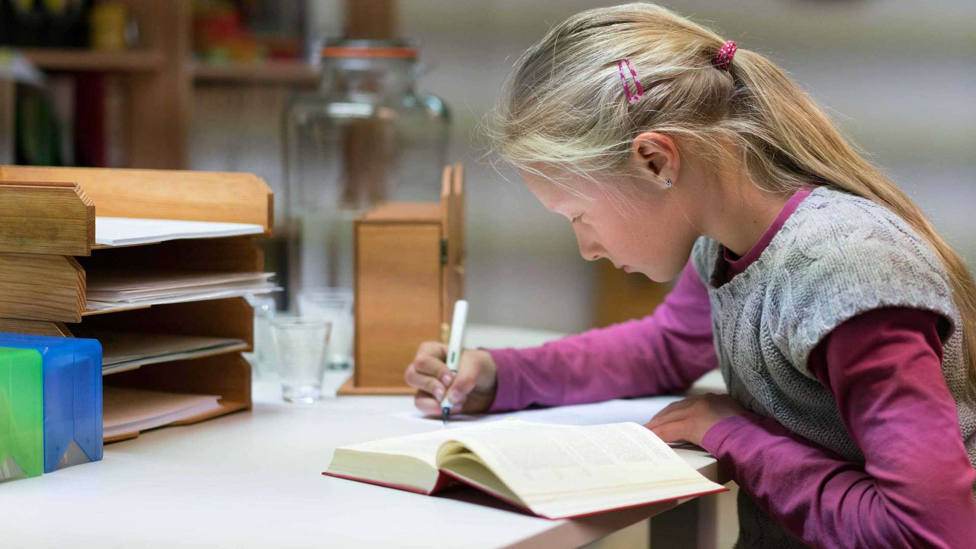 12-jähriges Mädchen studiert konzentriert die Bibel und macht sich ihre Notizen.